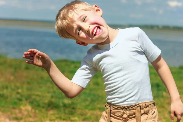 Menino brincando e brincando, mostrando língua e fazendo — Fotografia de Stock