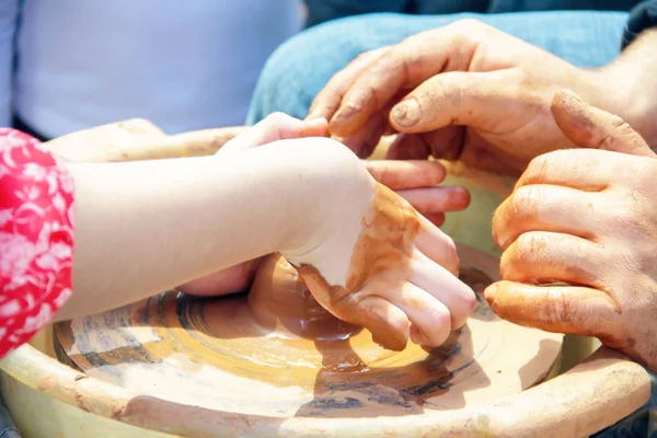 Master potter çocuk bir sürahi bir potte üzerinde yapmayı öğretir.