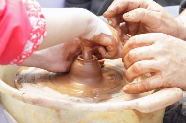 Master potter çocuk bir sürahi bir potte üzerinde yapmayı öğretir.