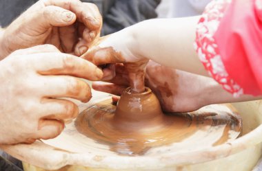 Master potter çocuk bir sürahi bir potte üzerinde yapmayı öğretir.