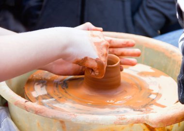Master potter çocuk nasıl bir sürahi yapmak öğretir.  