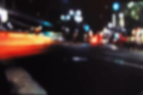 Borrão nocturno. luz embaçada bokeh fundo se movendo ao longo da cidade — Fotografia de Stock