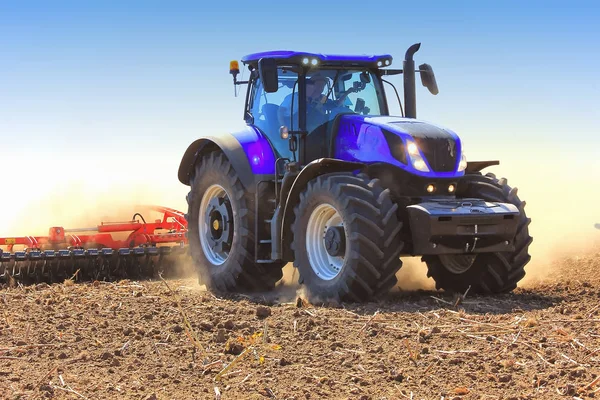 Werk van een trekker op een tarweveld. Gebied van trekker ploegen. — Stockfoto