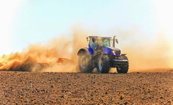 Робота потужного трактора в польовому вирощуванні і культивуванні . — стокове фото