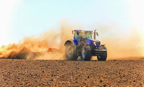 Trabalho de um poderoso trator em cultivo de campo e cultivo . — Fotografia de Stock