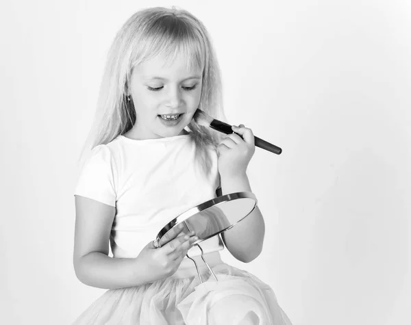 Happy little girl colors face cosmetics with mirror in on white — Stock Photo, Image