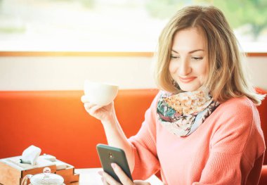bir smartphone ve bir fincan kahve çok güzel kızla neşeli şaşırttı