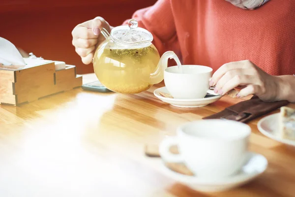 Női kezek öntsünk egy csésze forró tea. Reggeli a café.arom — Stock Fotó