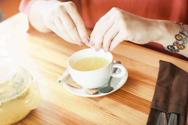 Női kezében egy csésze forró tea Öntsük a cukor. Reggeli t — Stock Fotó