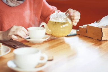 bir kız bir kafe ve sıcak bitkisel çay içme elleri. güzel kokulu 