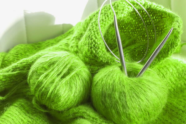 threads and knitting needles. Knitting blankets. Knitted sweater. Needlework as a hobby and business.