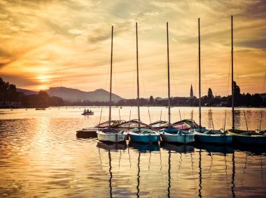 Yelkenli teknelerde Viyana'da Alte Donau, gün batımında