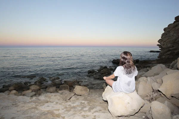 Chica meditando en una playa — Foto de Stock