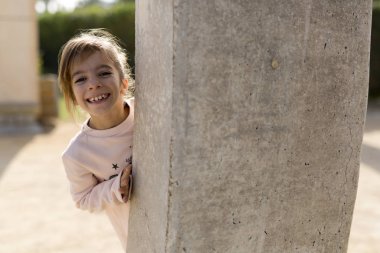 Taştan bir duvar arkasındaki kız.
