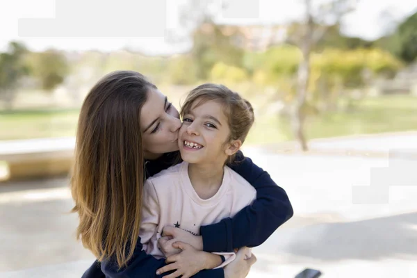 Teen giving a kiss to her younger sister — Stock Photo, Image