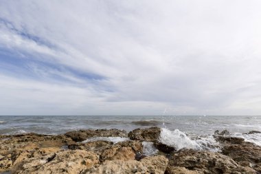 Santa Pola dalgalarda ile kayalık plaj.
