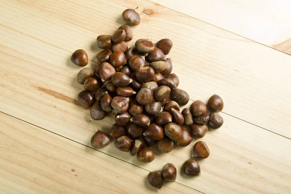 Chestnuts on pine wood background. — Stock Photo, Image