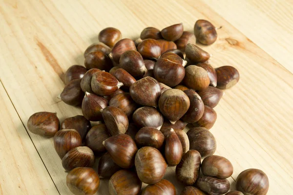 Castagne su sfondo di legno di pino . — Foto Stock