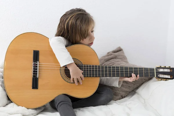 Девочка учится играть на классической гитаре — стоковое фото