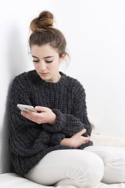 Genç kadın cep telefonu beyaz bir arka plan üzerinde seyir. 