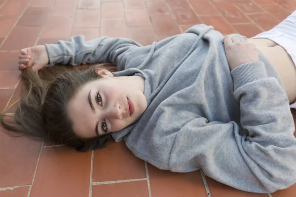 Young woman lying on laid floor. — Stock Photo, Image