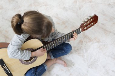 9 yaşındaki kız gitar çalmayı öğrenme. 