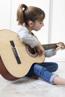 9 yaşındaki kız gitar çalmayı öğrenme. 