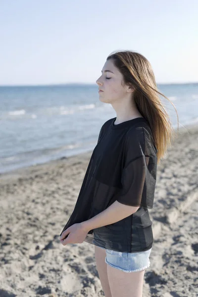 Adolescente avec les yeux fermés isolé sur la plage . — Photo