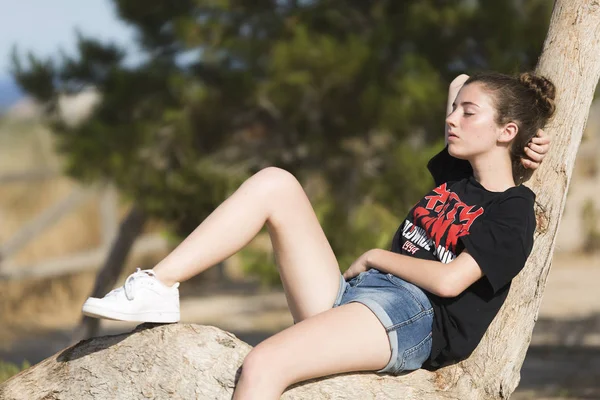 Teenage girl asleep on top of a tree. — Stock Photo, Image