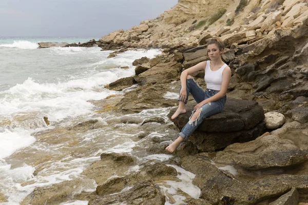 Adolescente sentada en las rocas . — Foto de Stock