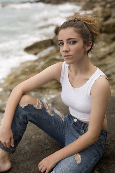 Adolescente sentada en las rocas . —  Fotos de Stock