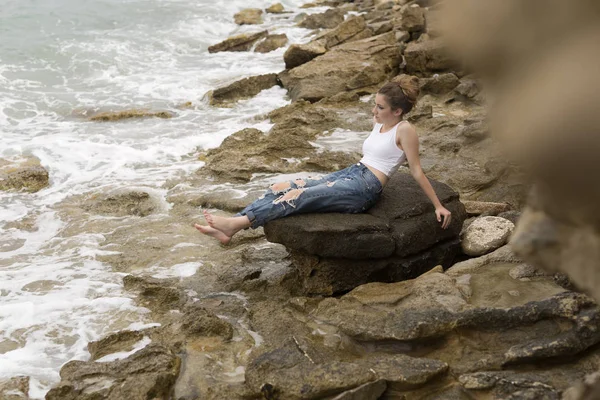 Adolescente sentada en las rocas . — Foto de Stock