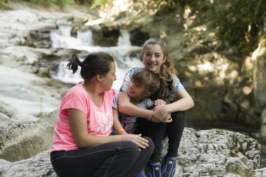 Biraz taş bir nehir yanında oturan aile