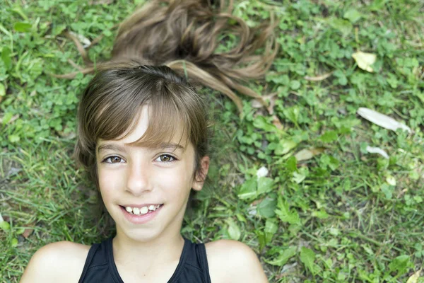 草の上に横たわる少女の顔. — ストック写真