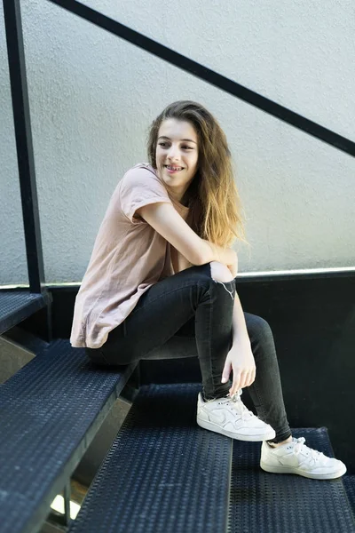 Adolescente sonriendo sentada en una escalera de metal —  Fotos de Stock