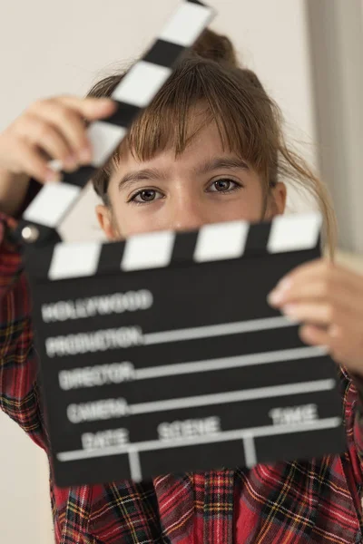 10-year-old girl with a clapboard of a hundred in her hands. — Stock Photo, Image