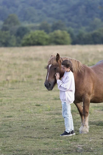 Adolescent avec des chevaux dans une prairie — Photo