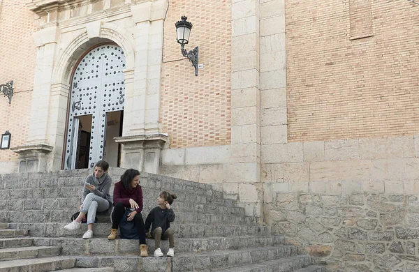 Anne ve kızı yanındaki kilise Altea, Alicante, İspanya ilinin merdivenlerde oturan.