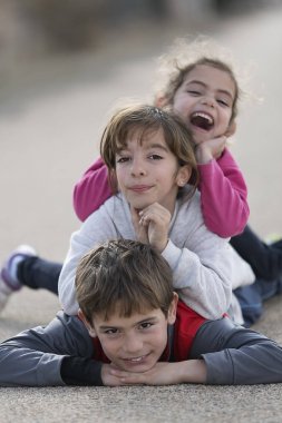 Üç çocuk zemine üste yatan. 