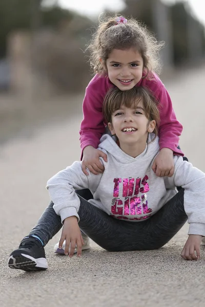 6 anos de idade menina apoiada por ela 10 anos velho primo . — Fotografia de Stock