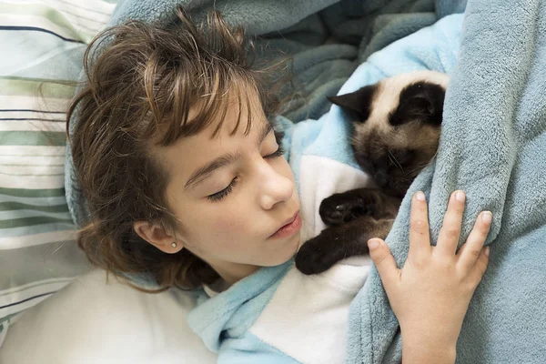 Alszik az ágyban az ő macska a top 10 éves lány. — Stock Fotó