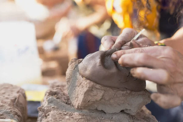 Hands of a person making a clay sculpture. Horizontal shot with natural light.