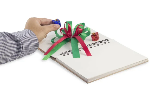 Рука держит подарочную коробку на книге изолированный белый фон — стоковое фото