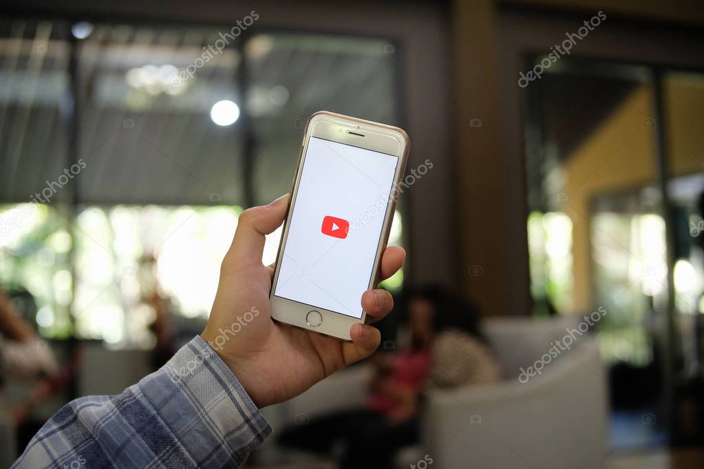 Chiang mai, Thailand - January 30 2017 : Man in blue plaid wear holding iphone 6 white color with youtube application logo on screen, copy space, for presentation product