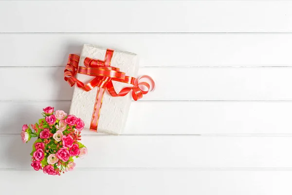 Pohled shora Vánoční dárková krabička na dřevěný stůl bílé pozadí, Fl — Stock fotografie