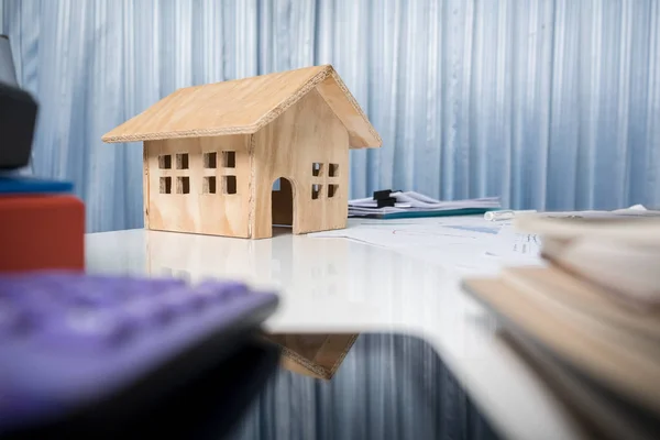 Бізнес-стіл крупним планом з дерев'яною моделлю будинку . — стокове фото