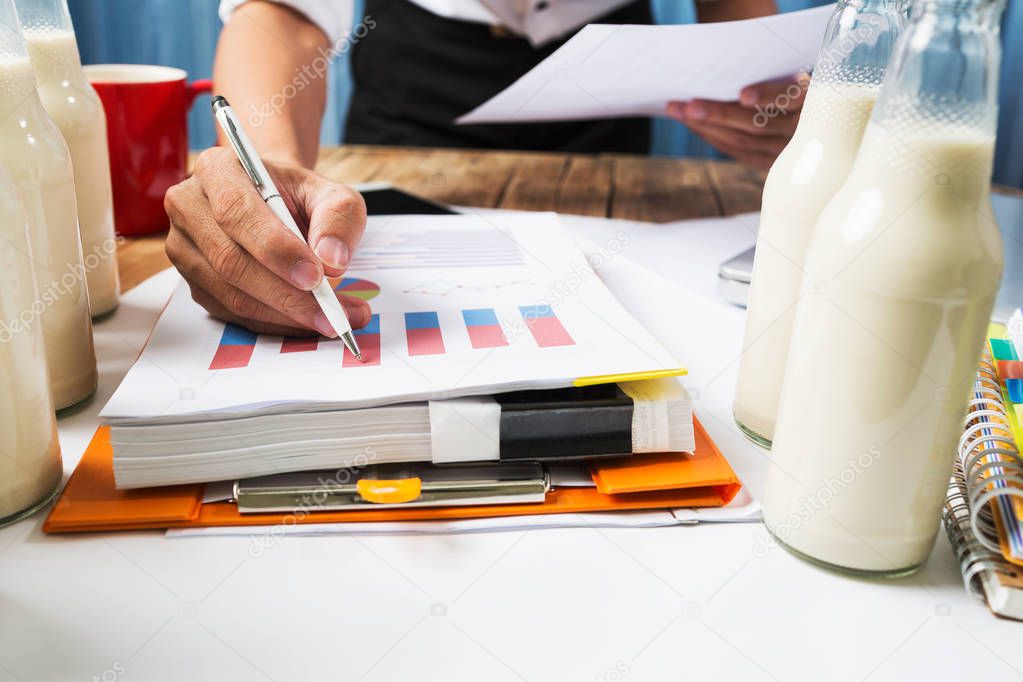 Business man working at milk bottle quality control hard job con