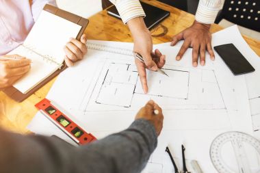 Danışmanlık mühendislik ekibi ortak girişimler için ticari binalar inşa etmek için kullanılan blueprint kontrol etmek için meslektaşları arasında.