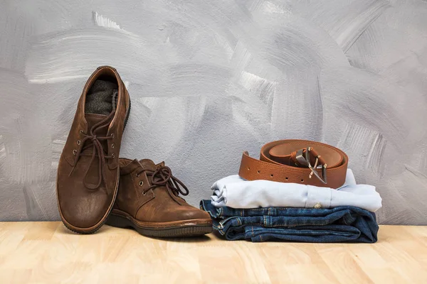 Asiático vintage estilo hombres ropa y jeans y bolso poner en madera mesa y loft concreto pared textura fondo . — Foto de Stock