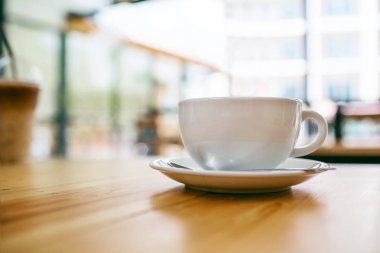 Sabahları kafe ve restoranda ahşap masada kahve fincanı ekranı.